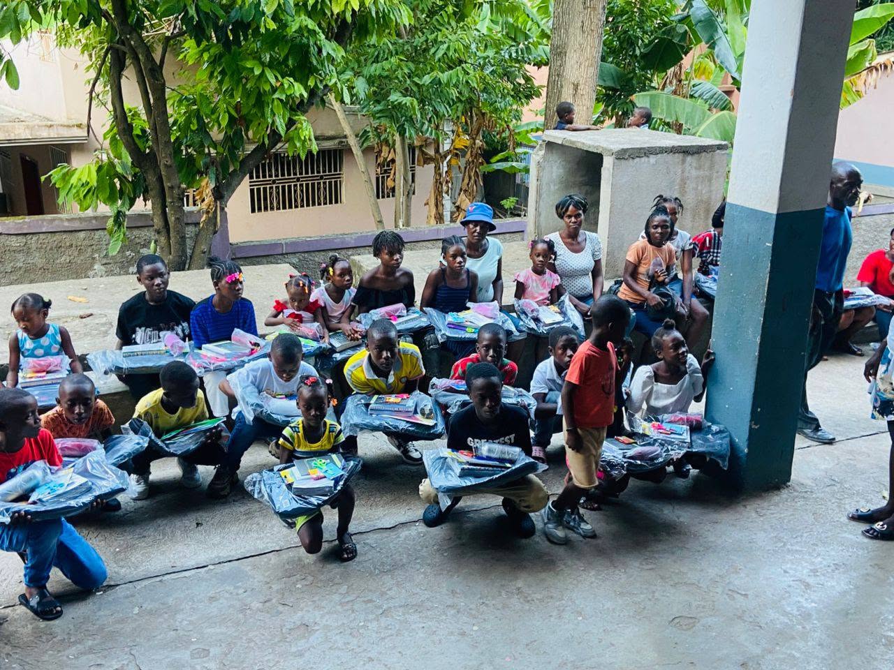 Groupe d'enfants avec les fournitures scolaires distribuées
