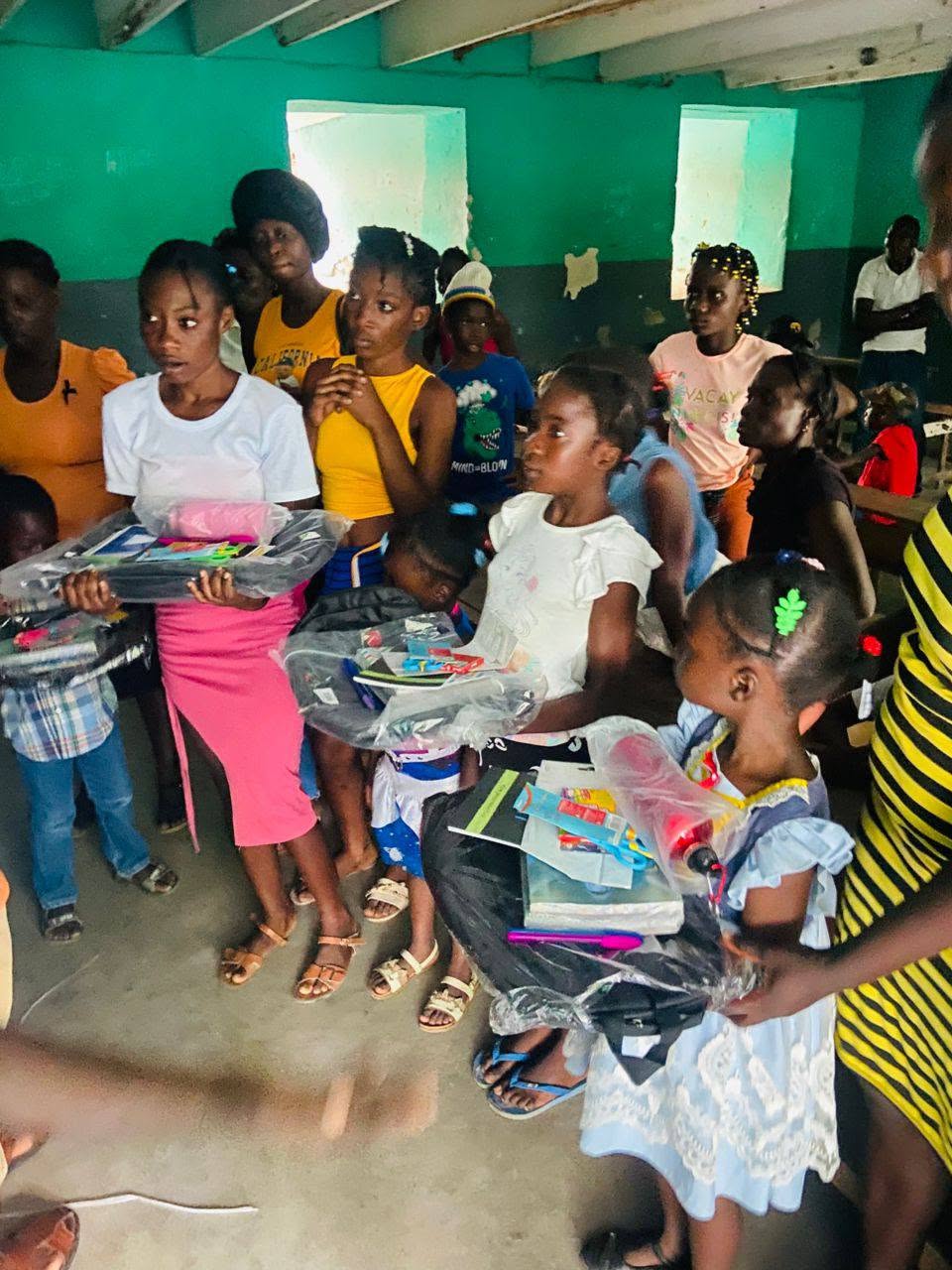 Enfants présentant leurs kits scolaires dans une salle