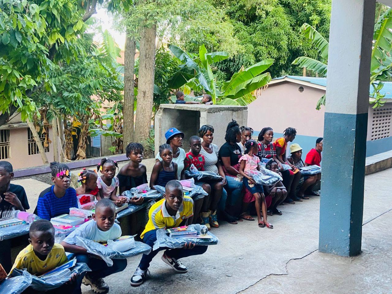 Enfants et familles réunis avec les kits scolaires