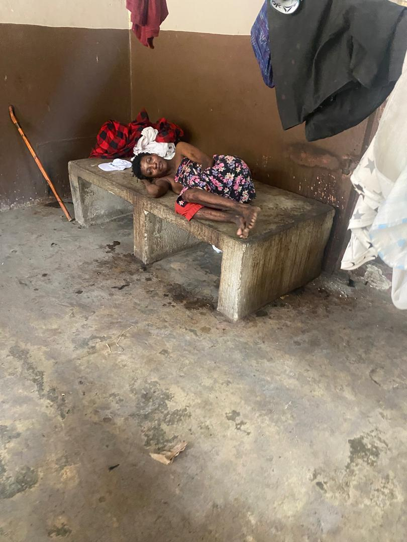 Une résidente de l'Asile Communal allongée sur un banc de béton